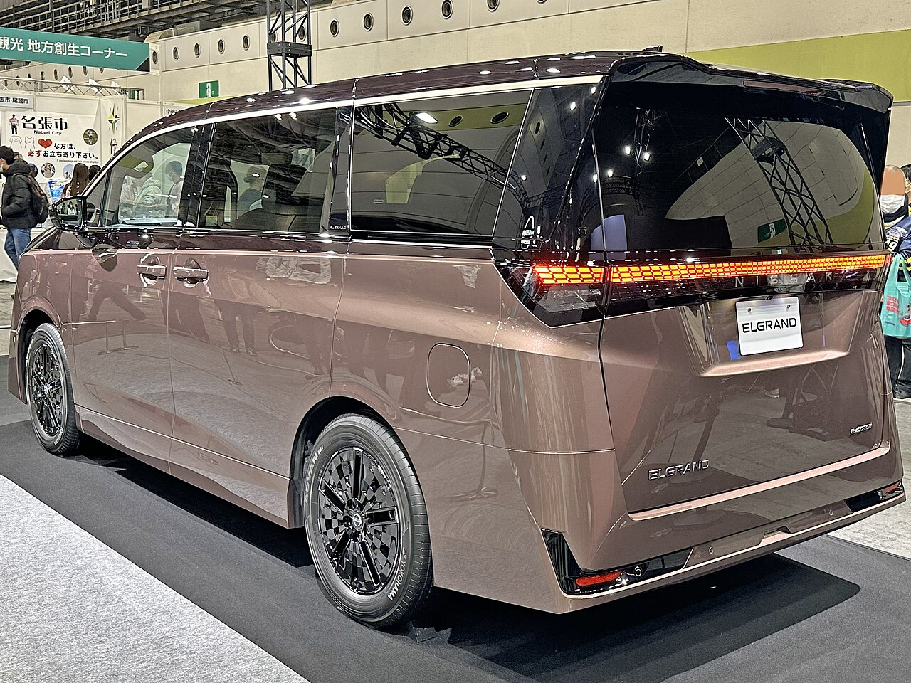 大阪モーターショー2025で展示された茶色の新型日産エルグランドE53を後方斜めから写した実車写真