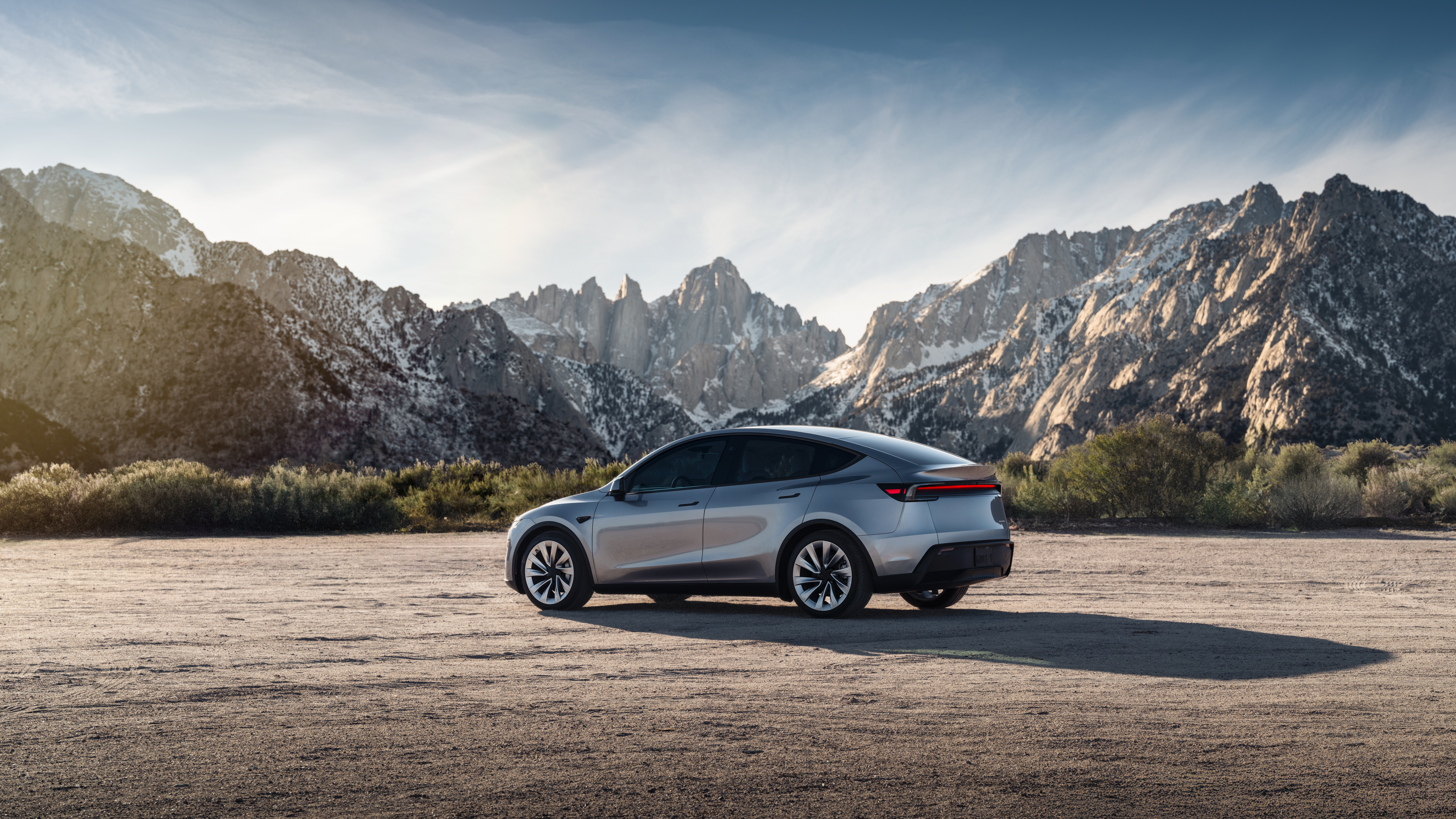山を背景に停車した銀色のModel Y。Teslaのグローバル向け公式素材