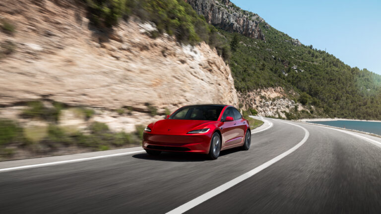 海沿いの道路を走る赤いModel 3 Premiumのグローバル向け公式画像