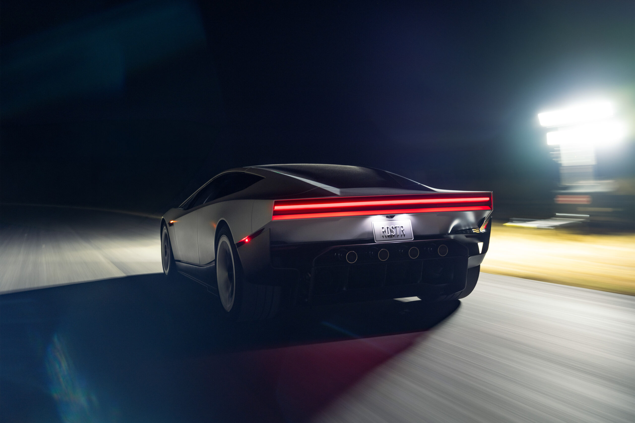 角張った白い車体と横一文字の赤いテールライトを斜め後ろから捉えた新型テスラ・ロードスターの公式画像